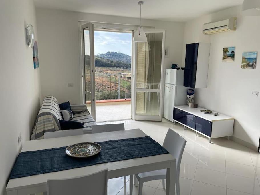a kitchen and living room with a table and a couch at Bilocale moderno 4 posti vicino al mare in Scarlino