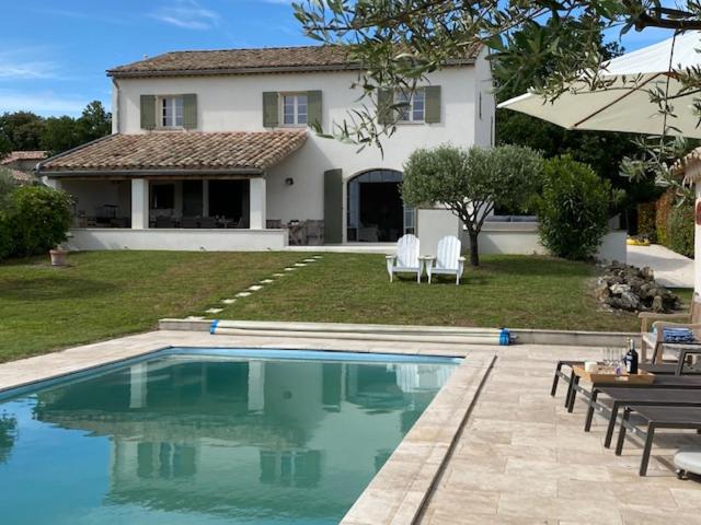 a swimming pool in front of a house at Maison Roquebeauresse in Pougnadoresse