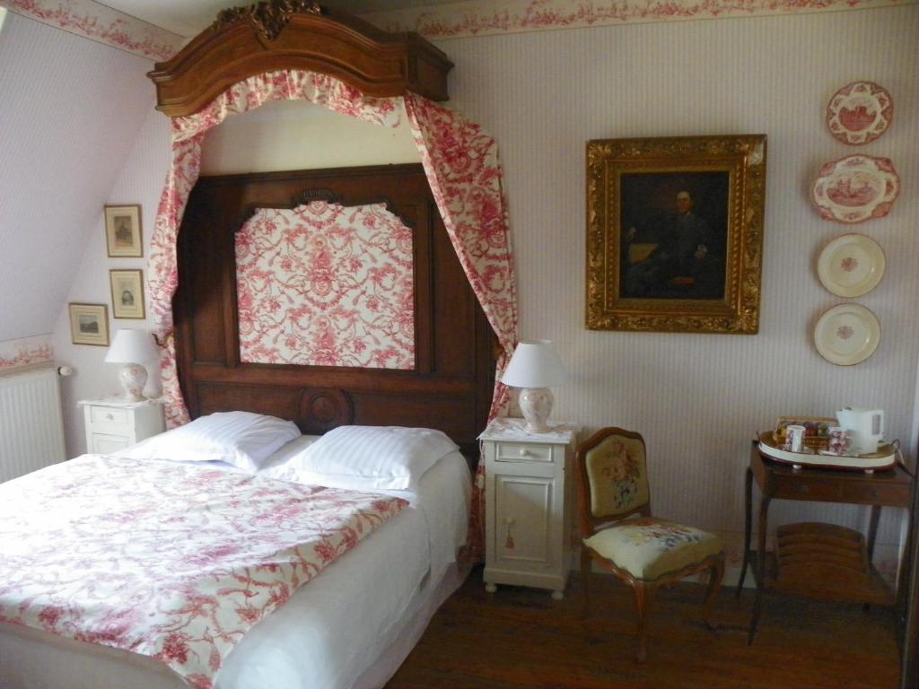 ein Schlafzimmer mit einem Bett, einem Tisch und einem Stuhl in der Unterkunft Le Prieuré Boutefol in Surville
