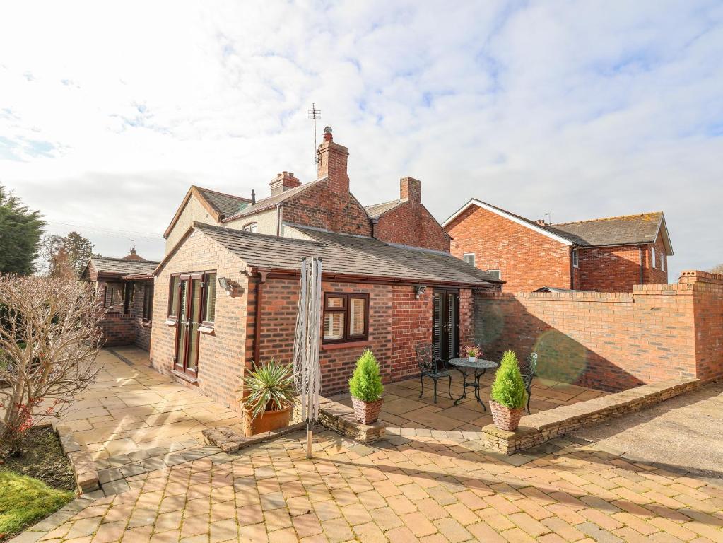 a brick house with a patio in front of it at 4 Green Farm Cottage in Chester