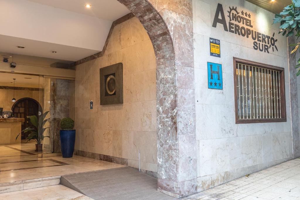 a building with an archway on the side of it at Aeropuerto Sur Hotel in San Isidro