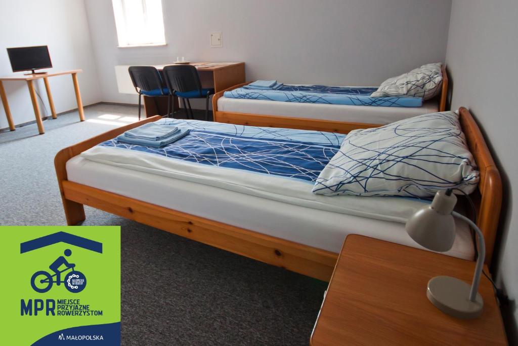 a bedroom with two beds and a desk with a lamp at Tarnowskie Centrum Informacji in Tarnów