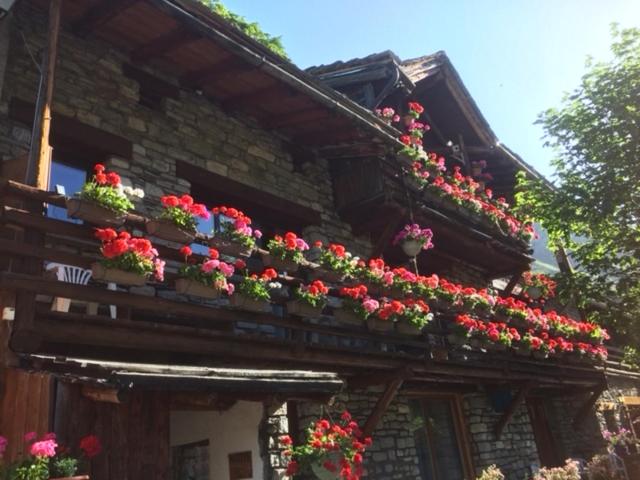 a building with flowers on the side of it at Le p'tit coin montagne in Bonneval-sur-Arc