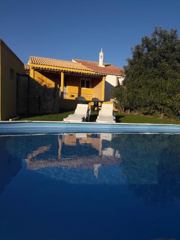 a house with a swimming pool in front of a house at Casa Alexandra in Poço Partido