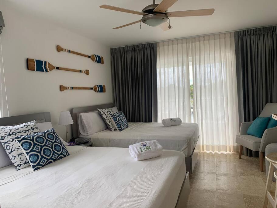 a hotel room with two beds and a couch at Acogedor departamento en Playa Dorada in San Felipe de Puerto Plata