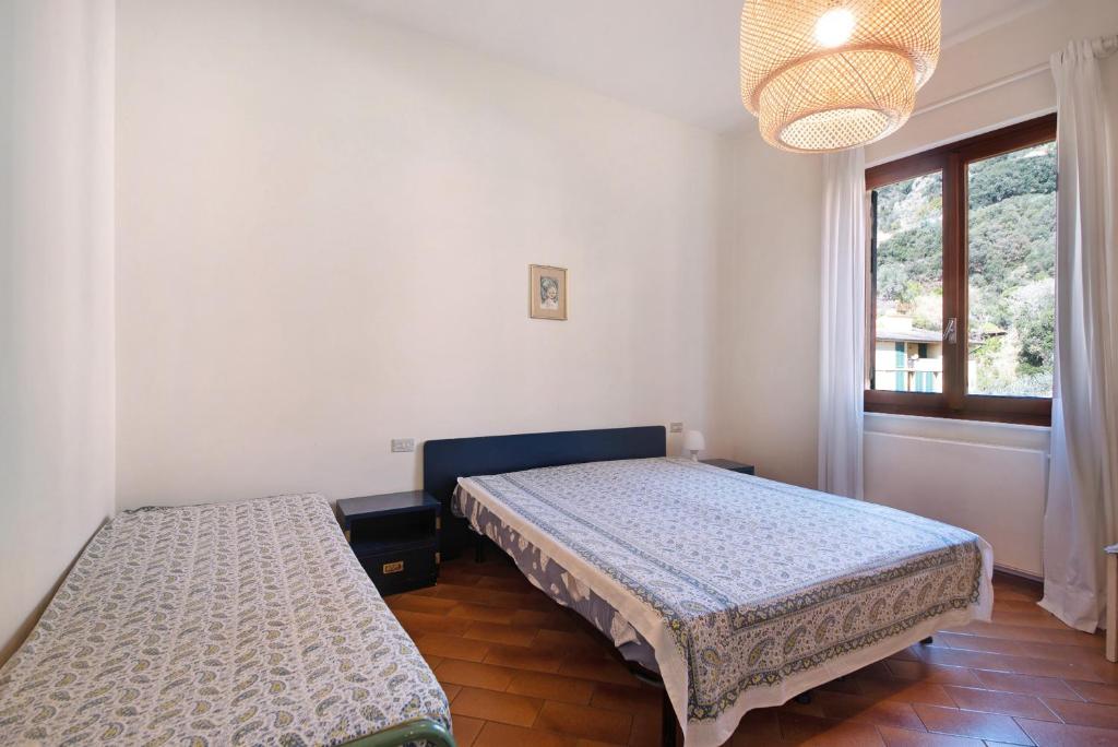 a bedroom with two beds and a window at Bilocale il Castello con parcheggio in Bonassola