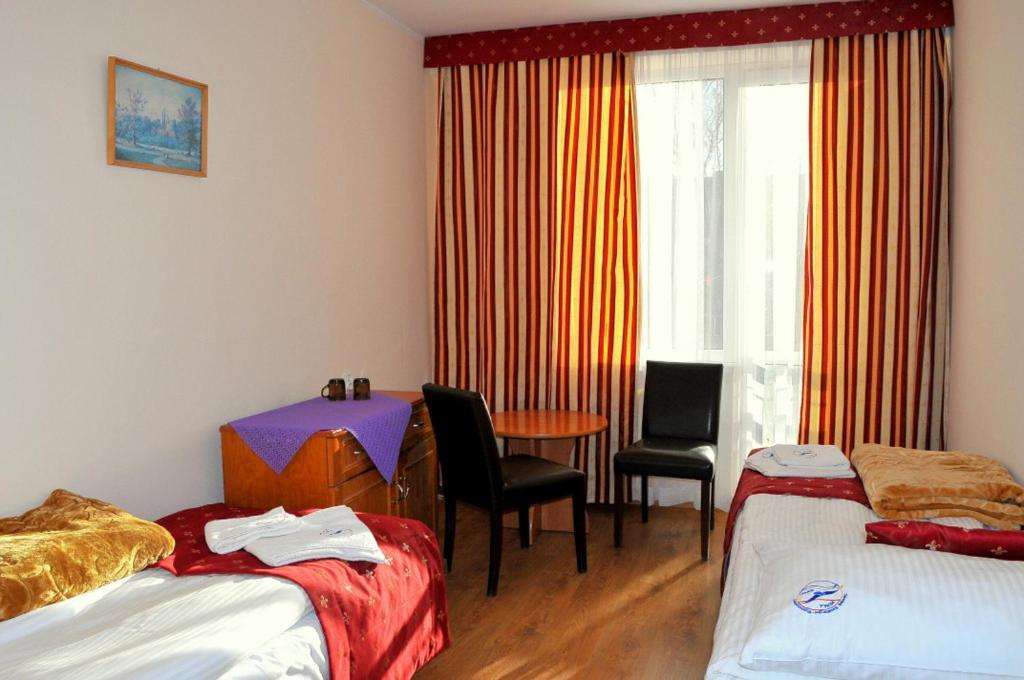 a room with two beds and a table and a window at OSW BALTIC Sopot in Sopot