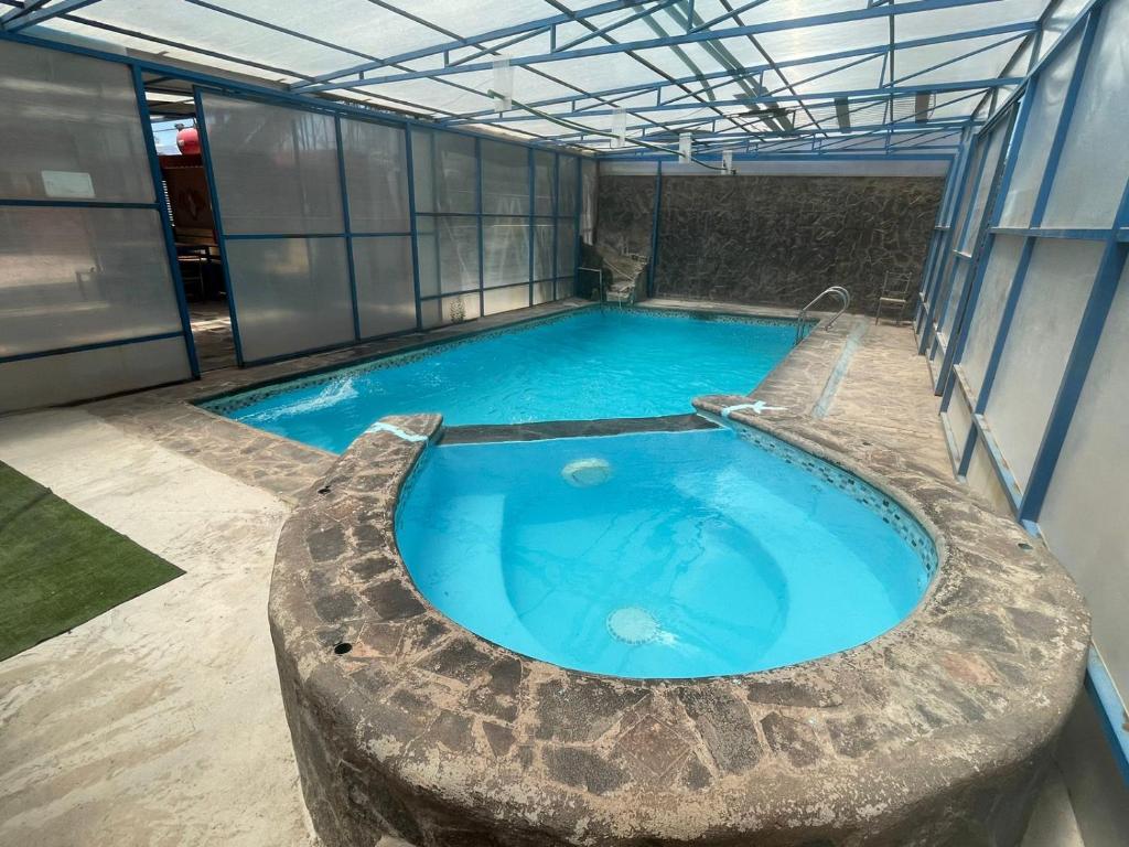 a large swimming pool in a building at Hostal El Amigo Lucho in San Pedro de Atacama