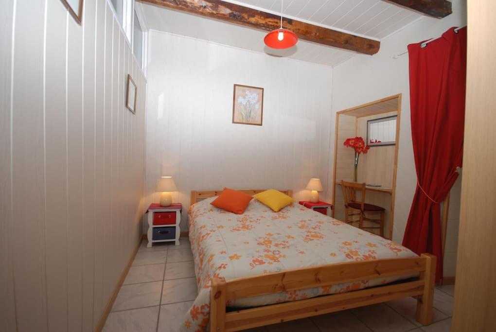 a small bedroom with a bed and a red curtain at Gîte Elisa in Vals-les-Bains