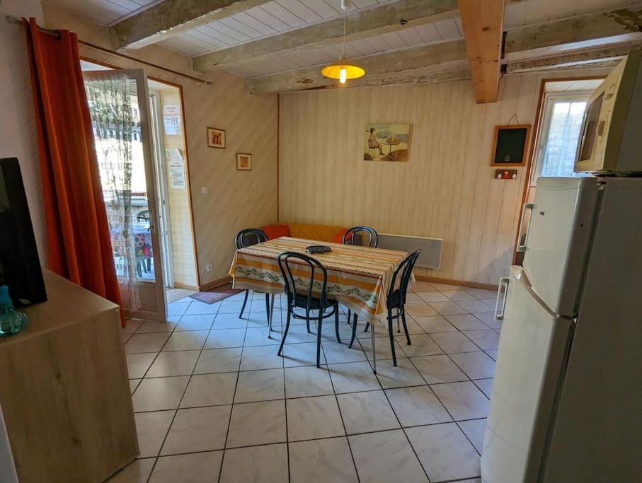 a kitchen with a table and chairs and a refrigerator at Gîte Elisa in Vals-les-Bains