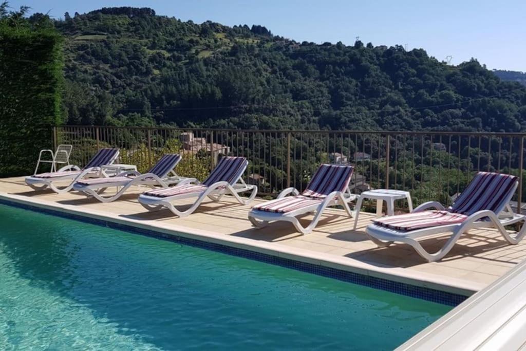 a row of lounge chairs next to a swimming pool at Gîte Elisa in Vals-les-Bains