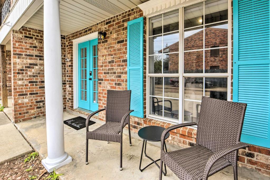 a porch with three chairs and a blue house at Pet-Friendly Lafayette Vacation Rental! in Lafayette