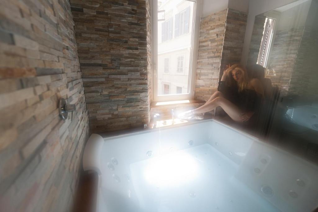 a woman sitting in a bath tub in a room at iRooms - Spanish Steps in Rome