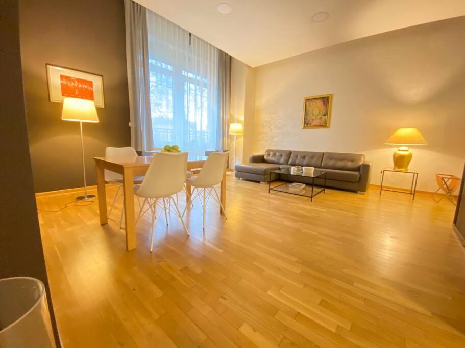 a living room with a couch and a table and chairs at Modern apartment,24/7 security,free parking in Belgrade