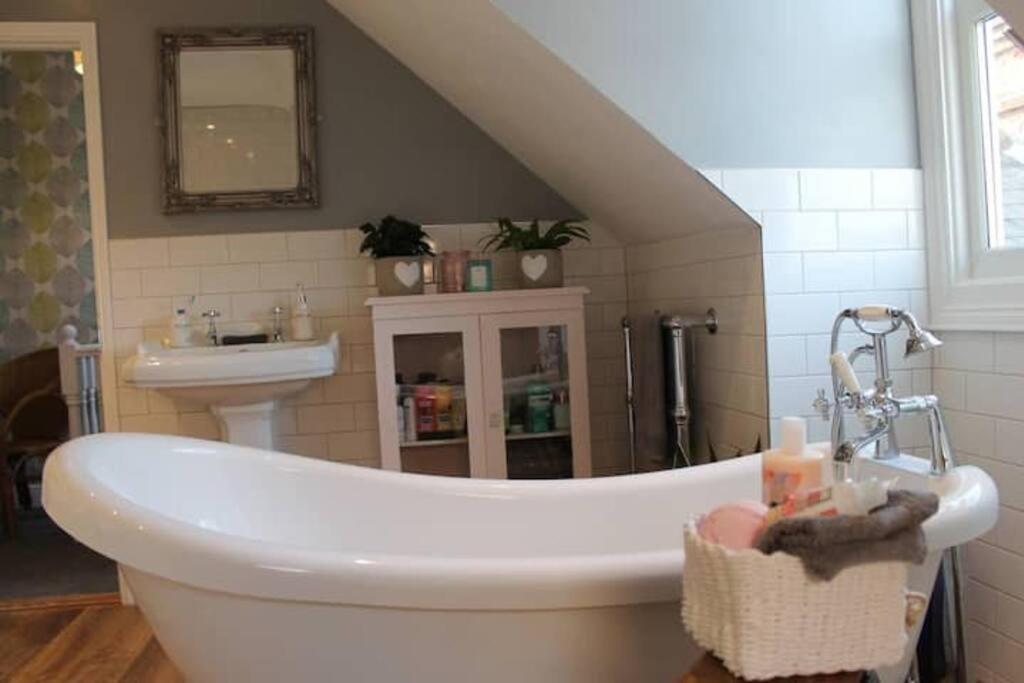 a bathroom with a bath tub and a sink at Stoneleigh in Felixstowe