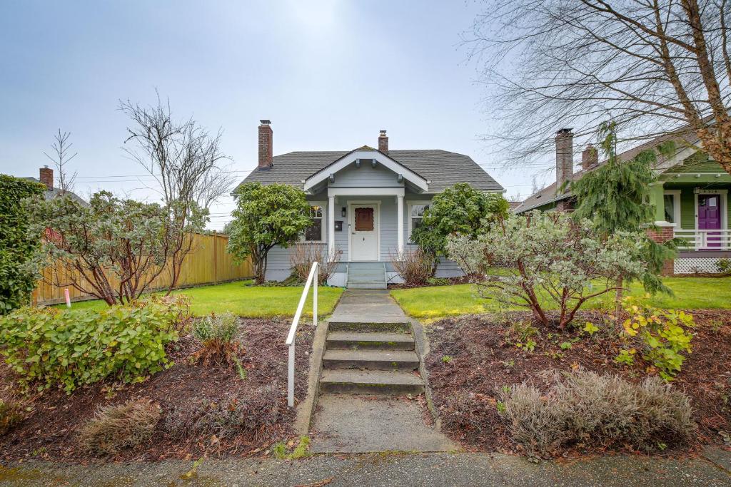 a white house with stairs leading to the front door at Charming Tacoma Vacation Home with Fenced Yard in Tacoma
