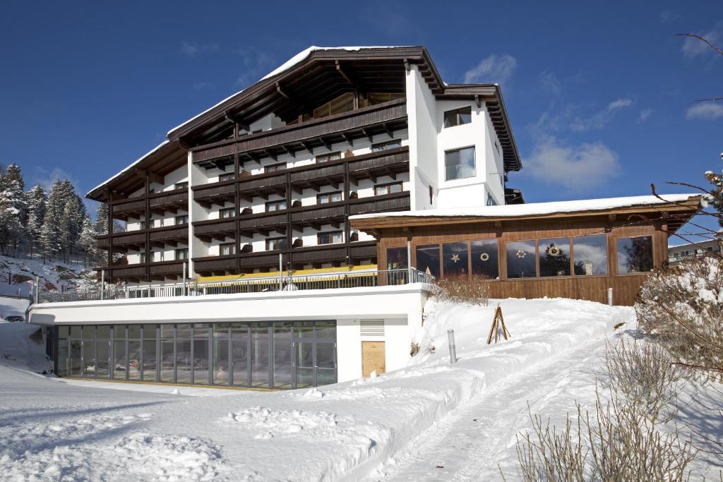 ein Gebäude im Schnee vor der Tür in der Unterkunft Hotel Achentalerhof in Achenkirch