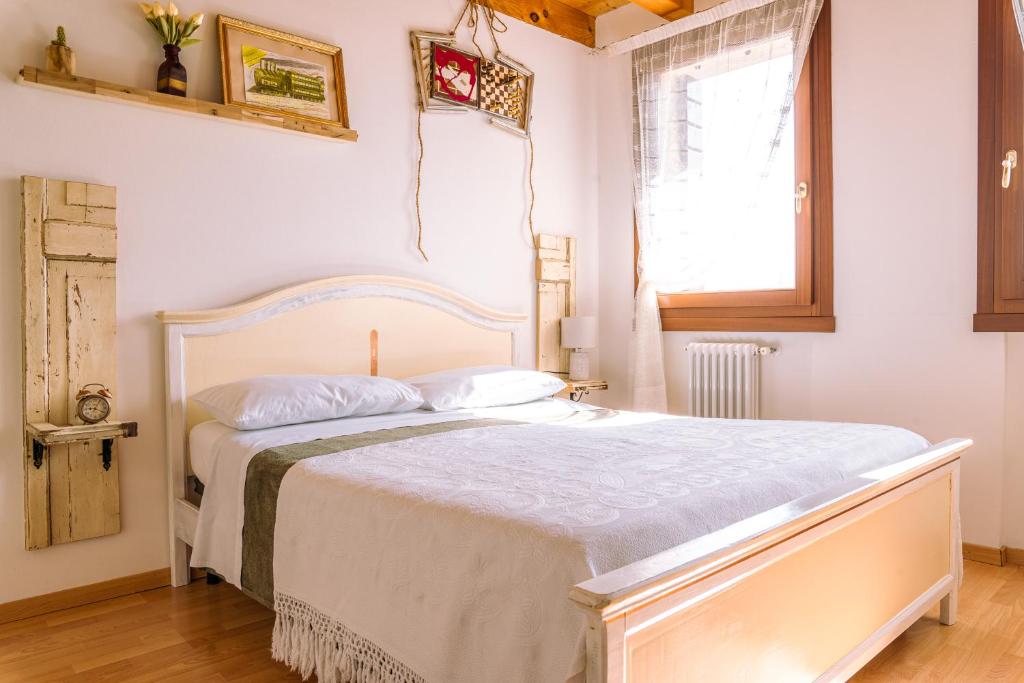 1 dormitorio con cama blanca y ventana en Venice's neighbour Home, en Mirano