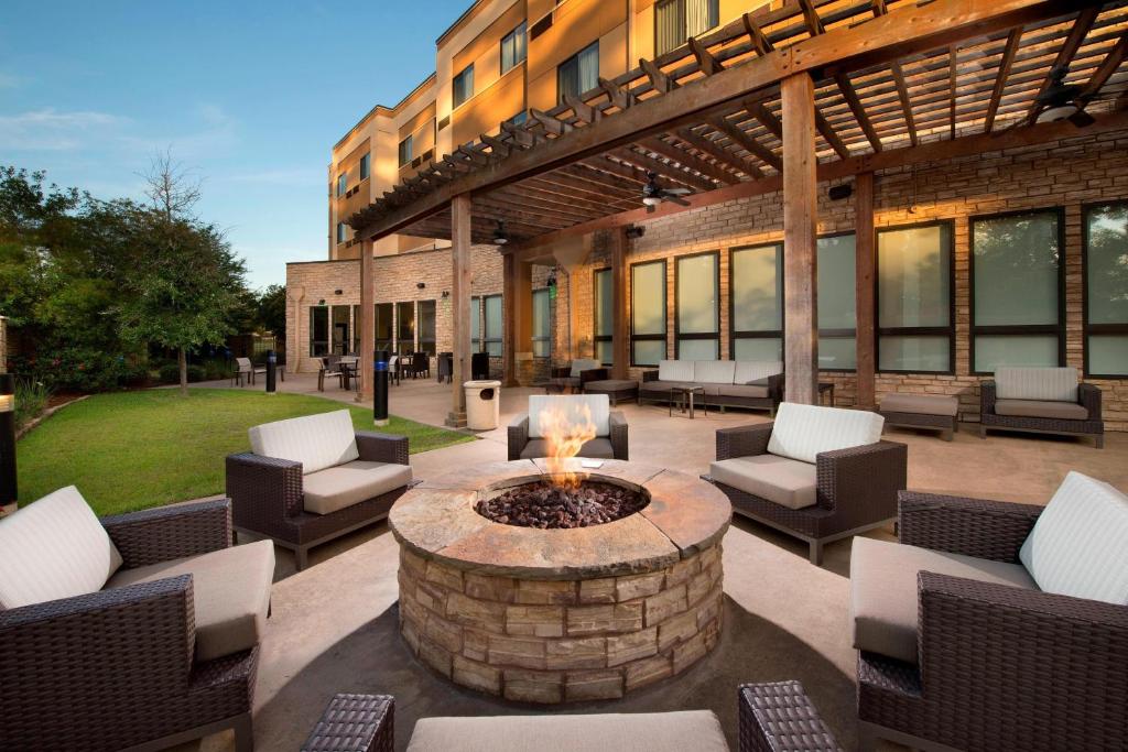 een patio met een vuurplaats voor een gebouw bij Courtyard by Marriott Lufkin in Lufkin