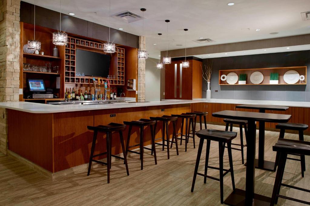 a bar with a bunch of stools in a restaurant at SpringHill Suites by Marriott Dayton Beavercreek in New Germany