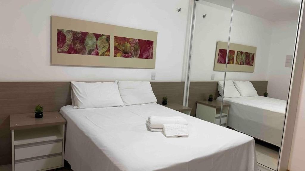 a bedroom with two beds and a mirror at Refúgio Beira Lago- Life Resort in Brasília
