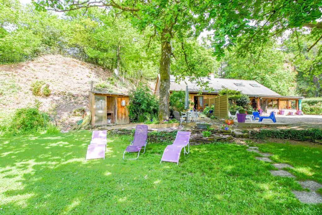 a group of purple chairs sitting in a yard at Gite des landes de la houssais in Guichen