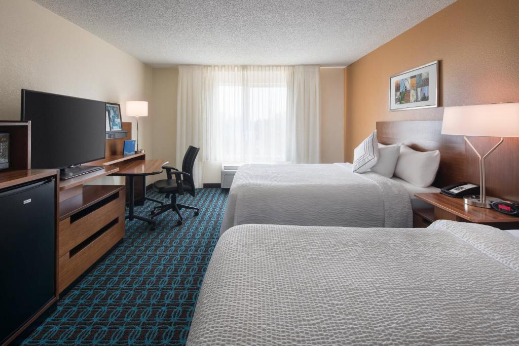 a hotel room with two beds and a flat screen tv at Fairfield Inn by Marriott Loveland Fort Collins in Loveland