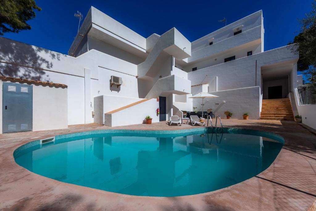 a house with a swimming pool in front of it at White suites 3 in Cala d´Or