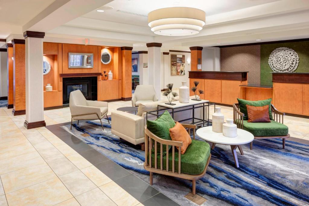 a lobby with chairs and tables and a fireplace at Fairfield Inn & Suites Wilmington Wrightsville Beach in Wilmington