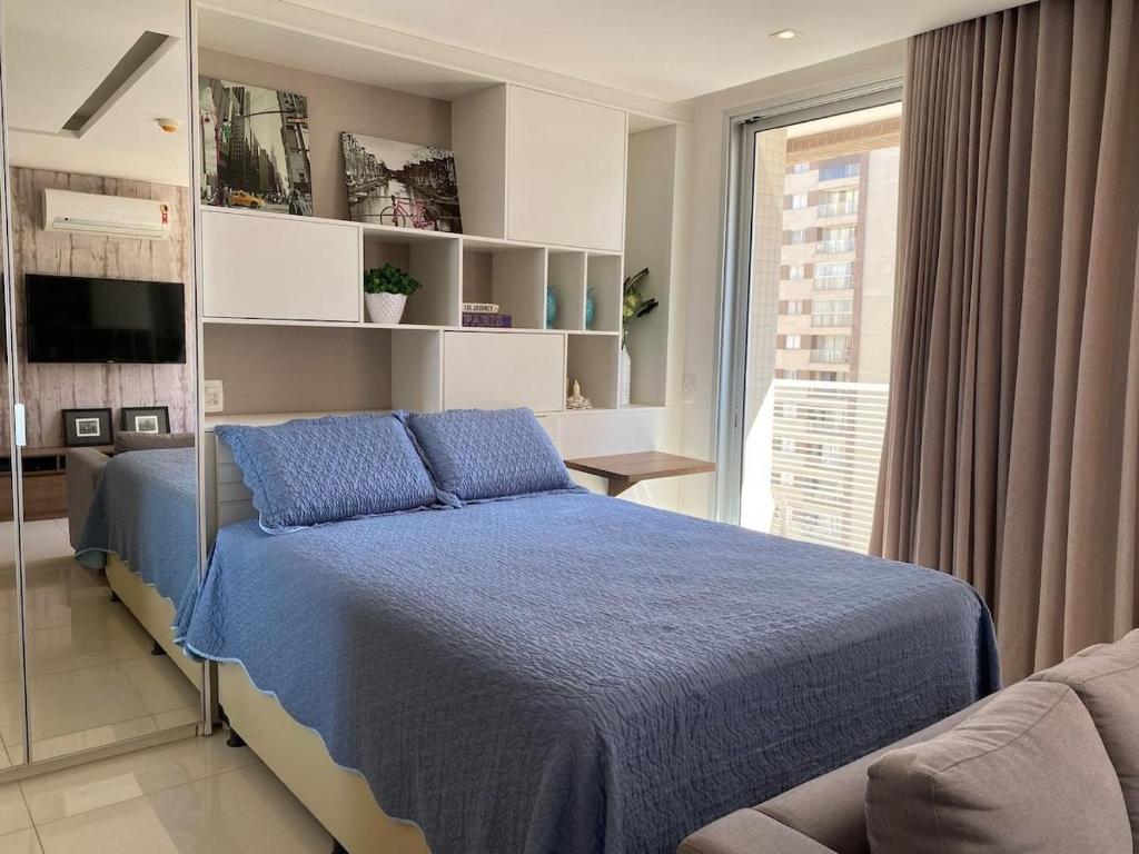 Un dormitorio con una cama azul y una ventana en Incrível Apto DF Plaza com vista en Brasilia