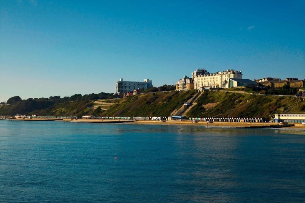 a body of water with buildings on top of a hill at Bournemouth Highcliff Marriott Hotel in Bournemouth