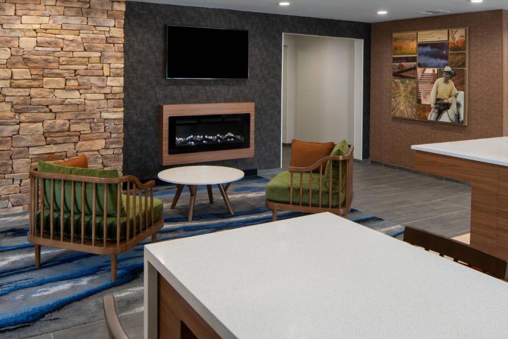 a lobby with a fireplace and chairs and a table at Fairfield Inn and Suites by Marriott Lake Charles - Sulphur in Sulphur