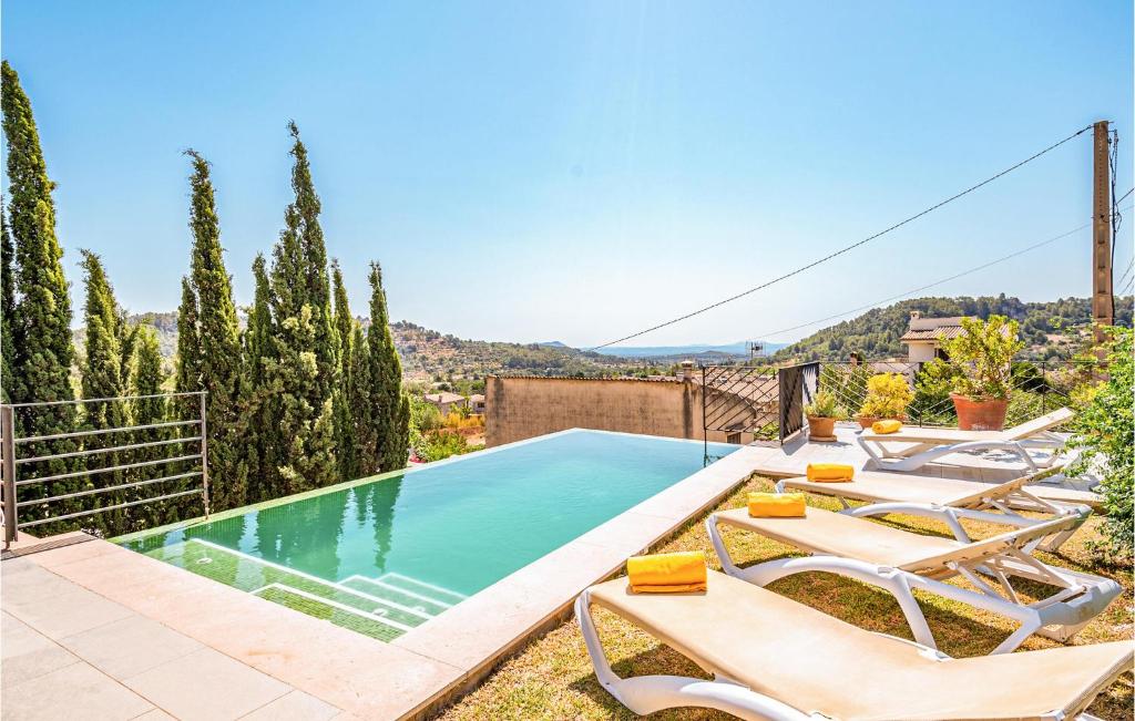 Mancor del ValleにあるBeautiful Home In Mancor De La Vall With 3 Bedrooms, Wifi And Outdoor Swimming Poolのラウンジチェア付きのプール、スイミングプールを提供しています。
