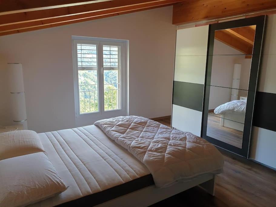 um quarto com uma cama grande e um espelho em Mansarda / Loft open space em Signora