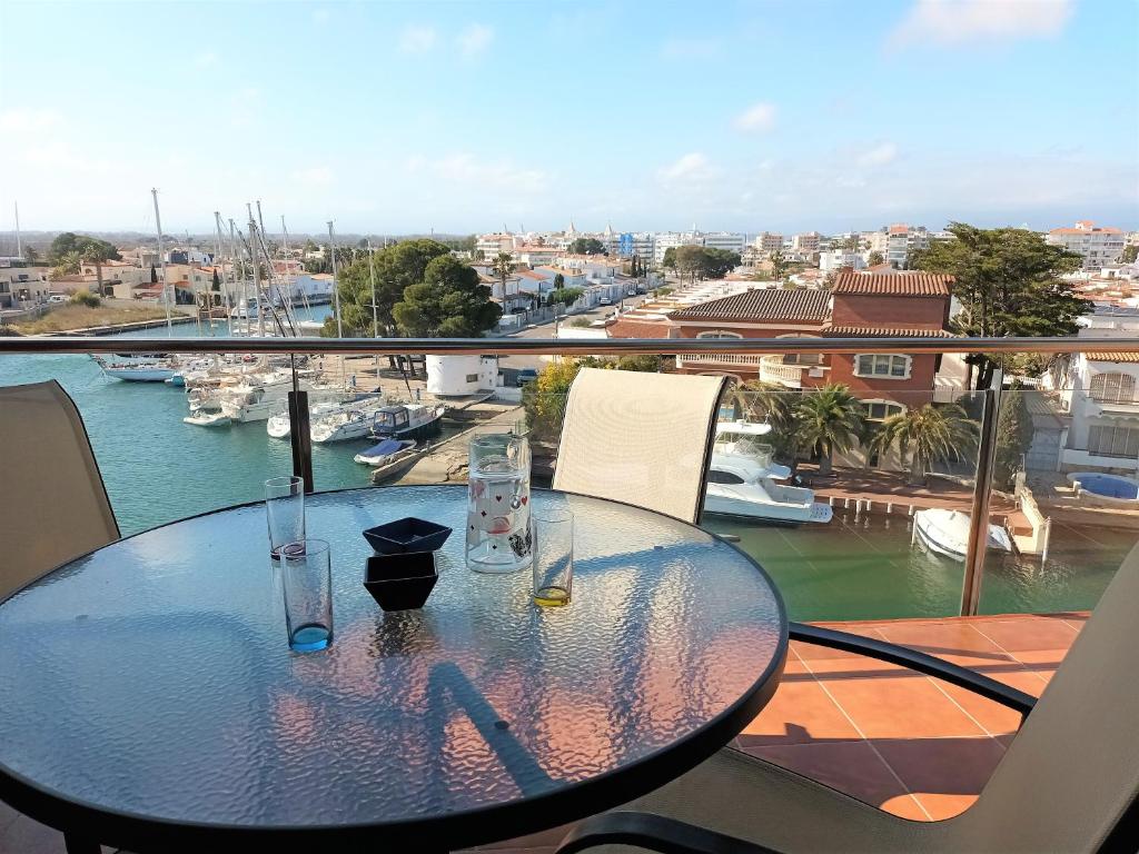 a glass table on a balcony with a view of a harbor at Global Immo 3360 LES MARINES GARBI 4-2 in Roses