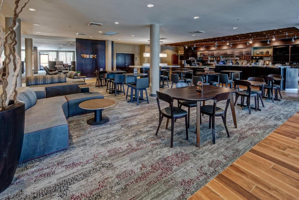 a restaurant with tables and chairs and a bar at Courtyard by Marriott Troy in Troy