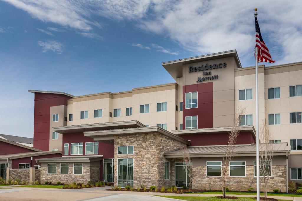 an exterior view of a hotel with an american flag at Residence Inn by Marriott Dallas Plano/Richardson at Coit Rd. in Plano