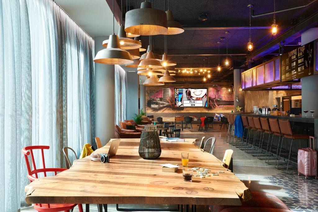 a dining room with a large wooden table and chairs at Moxy Dublin City in Dublin