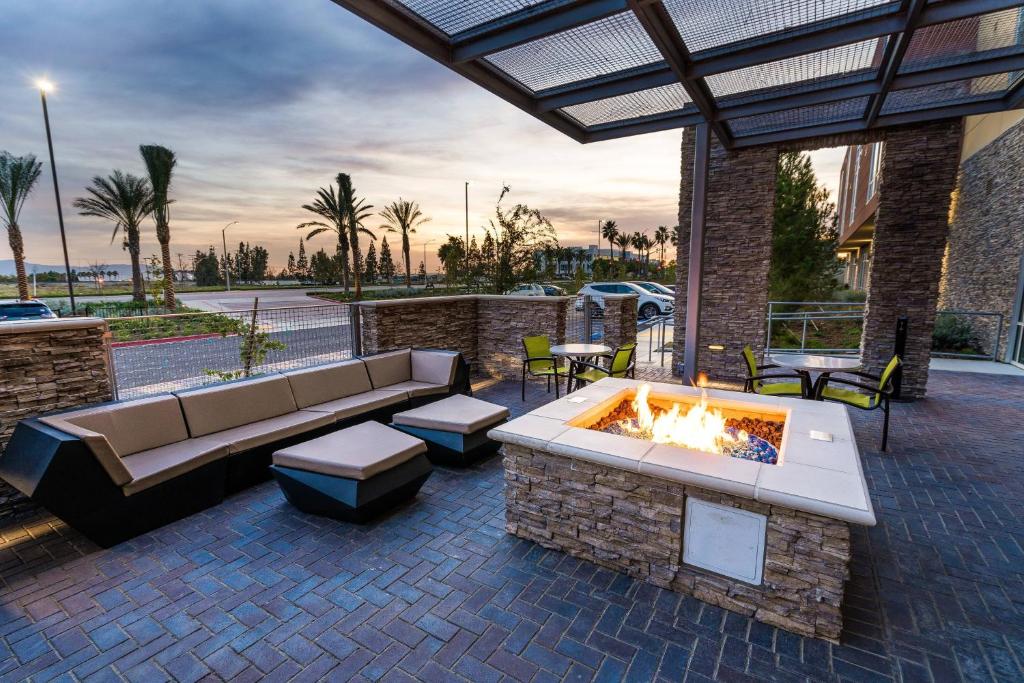 een patio met een bank en een vuurplaats bij SpringHill Suites by Marriott Ontario Airport/Rancho Cucamonga in Ontario