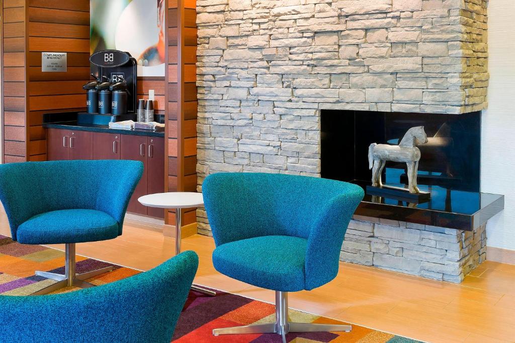 a lobby with two chairs and a fireplace at Fairfield Inn & Suites Lexington Keeneland Airport in Lexington