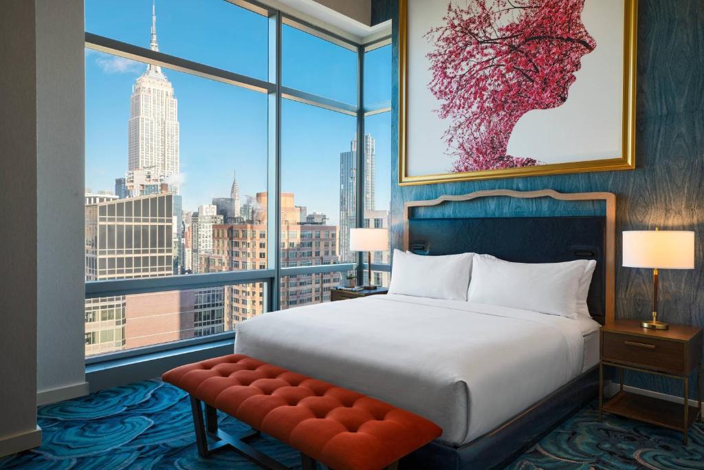 a bedroom with a bed and a large window at Renaissance New York Chelsea Hotel in New York