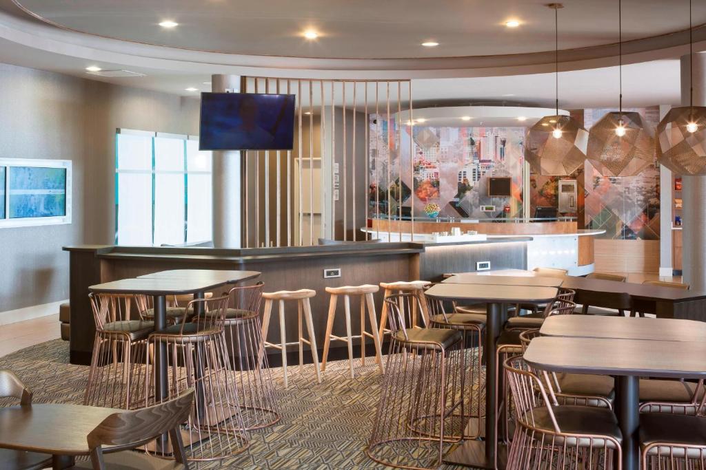 a restaurant with tables and chairs and a bar at SpringHill Suites by Marriott Salt Lake City Airport in Salt Lake City