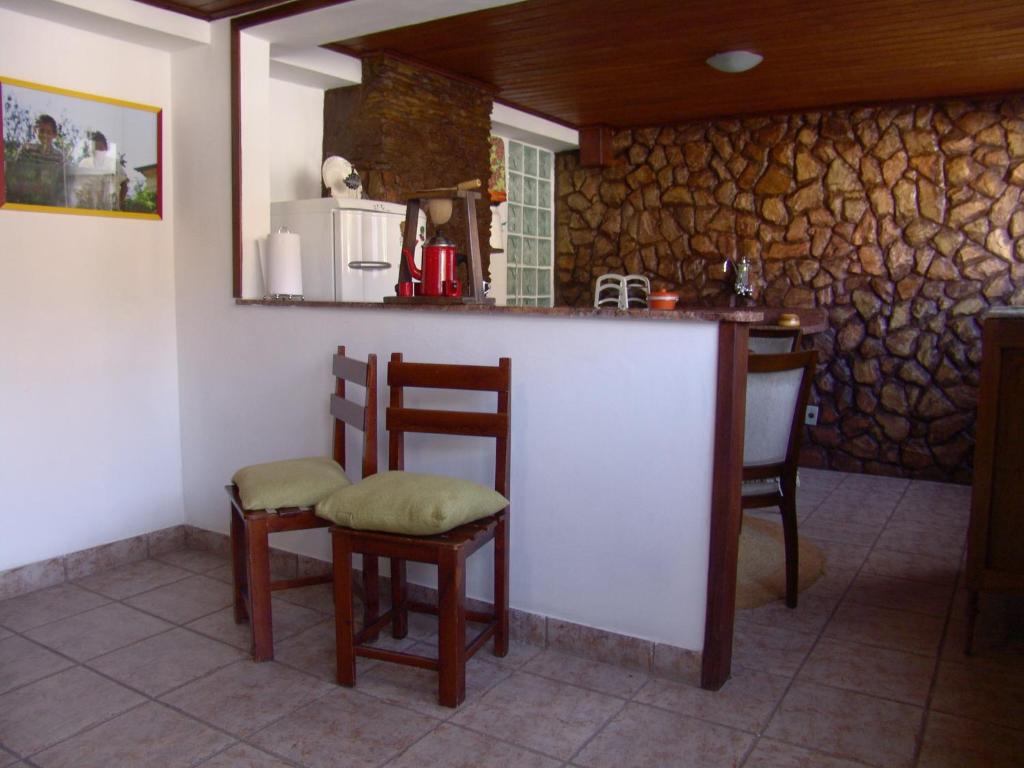 a kitchen with a bar with chairs and a counter at Casa de João in Ouro Preto