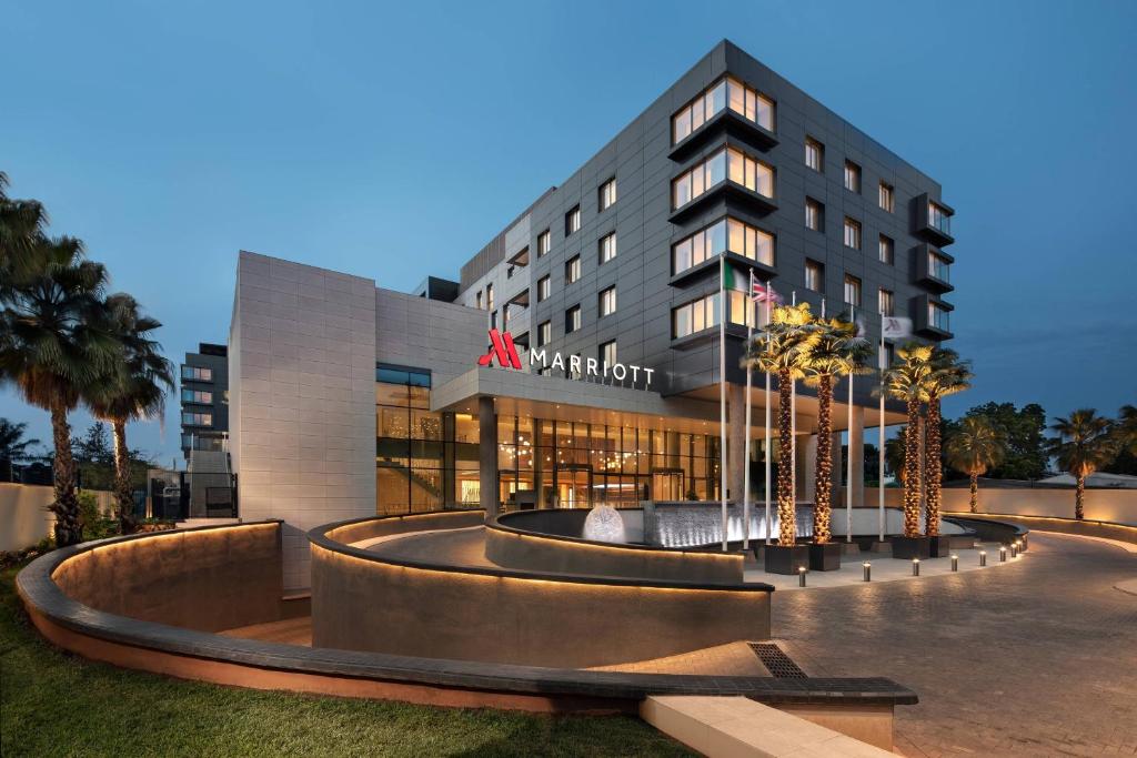 un bâtiment d'hôtel avec des palmiers devant lui dans l'établissement Lagos Marriott Hotel Ikeja, à Lagos