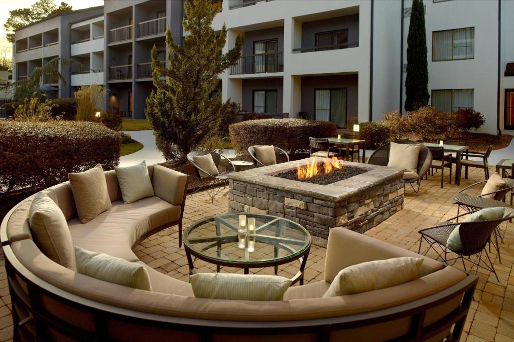 a patio with a fire pit with couches and tables at Courtyard Greenville Haywood Mall in Greenville