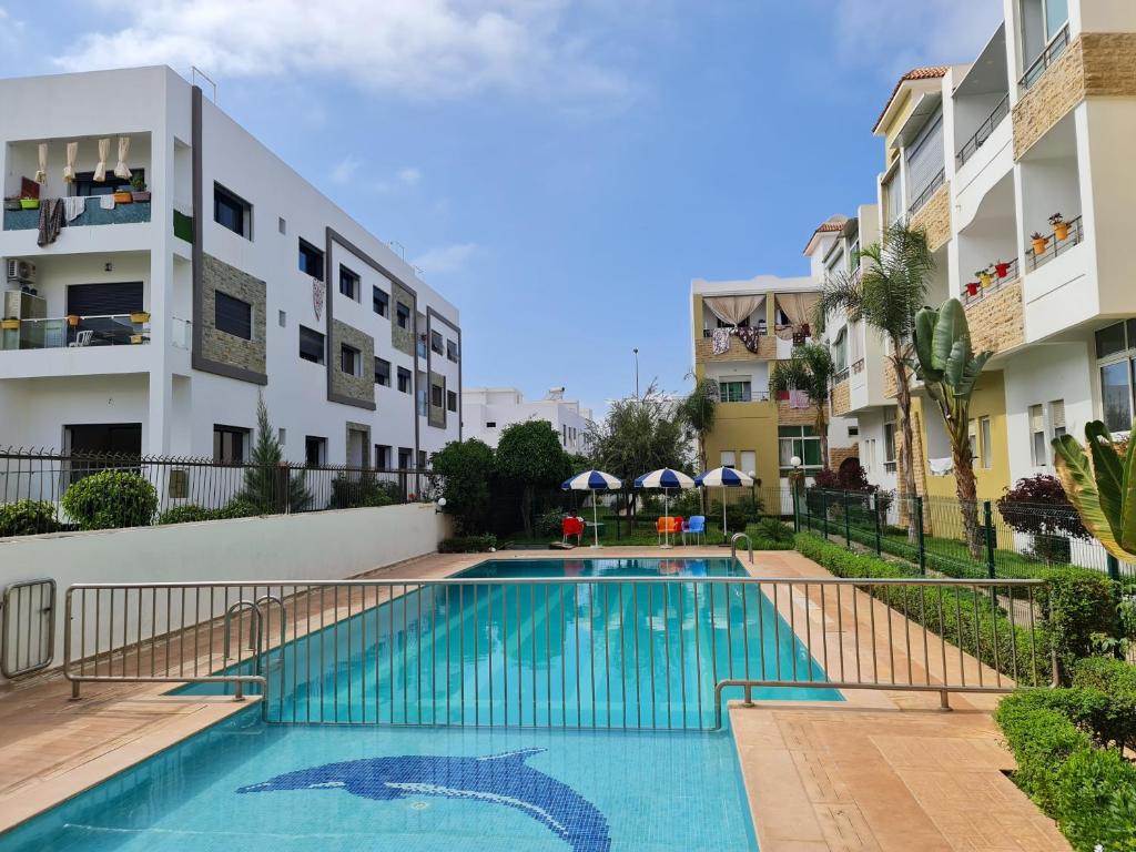 uma piscina no meio de um edifício em Agreable appartement dans une résidence calme sécurisée em El Harhoura