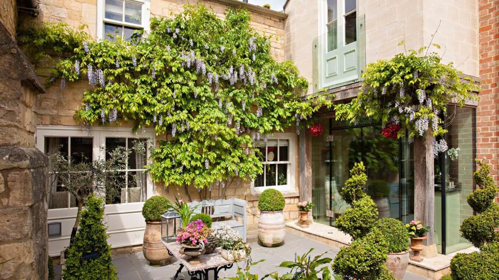 a building with a bunch of plants and flowers at Singer House in Chipping Campden