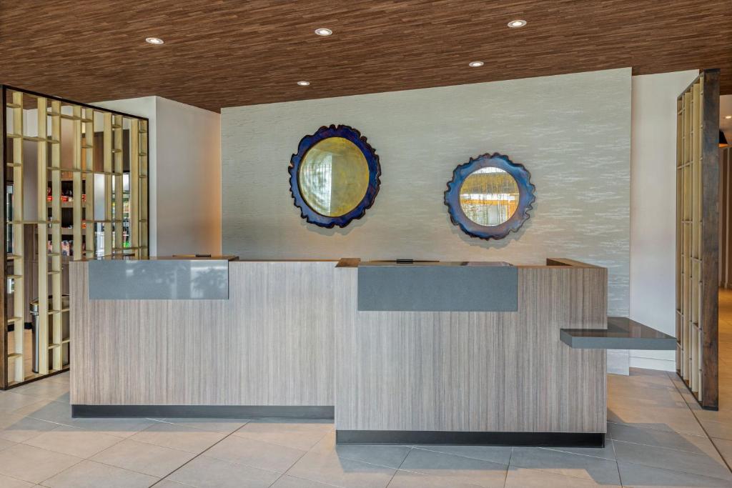 a lobby with a counter and two mirrors on the wall at Fairfield by Marriott San Jose Airport Alajuela in Alajuela City