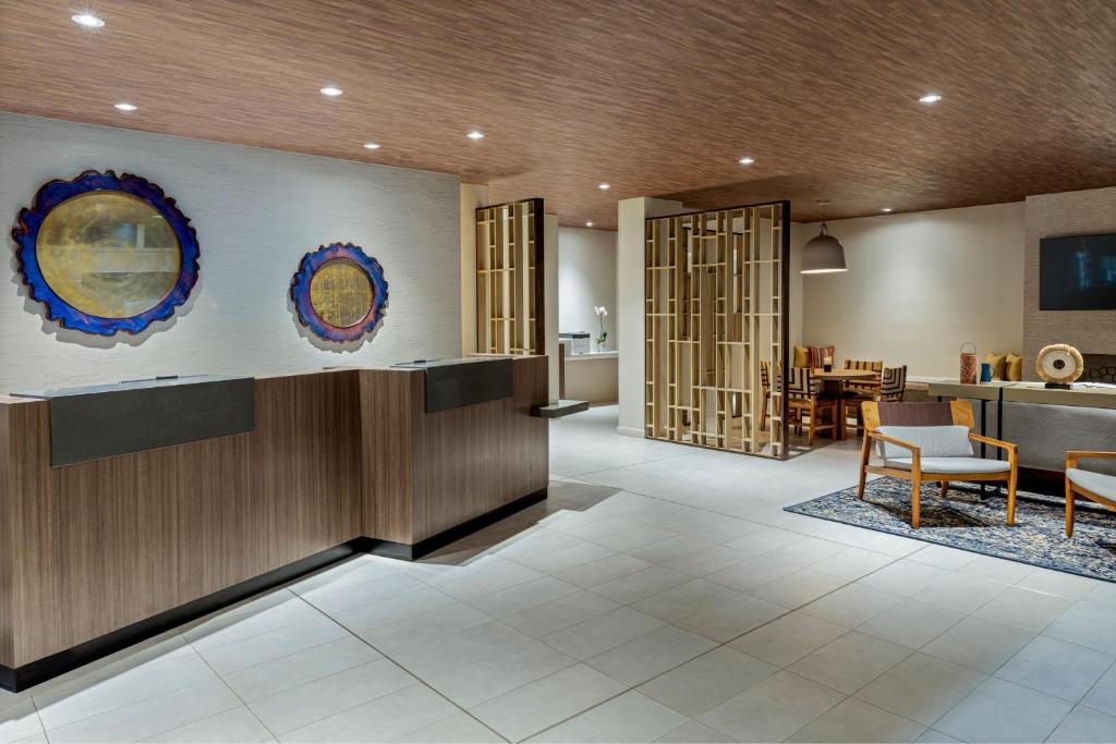 a lobby of a hotel with a dining area and a kitchen at Fairfield by Marriott San Jose Airport Alajuela in Alajuela City