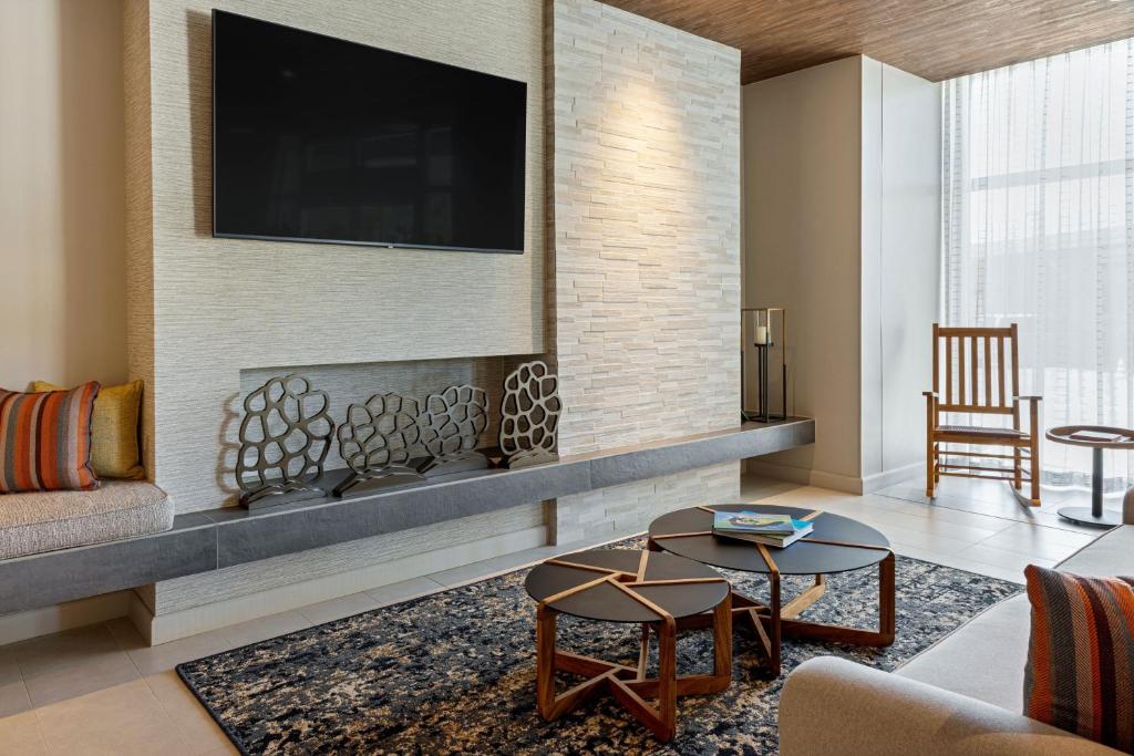 a living room with a fireplace and a tv at Fairfield by Marriott San Jose Airport Alajuela in Alajuela City